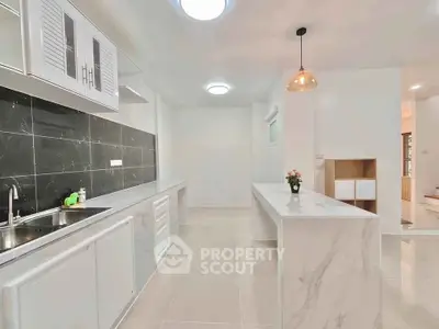 Modern kitchen with sleek white cabinetry and marble countertops