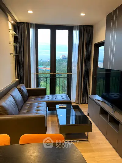 Modern living room with sleek furniture and large windows offering a scenic view.