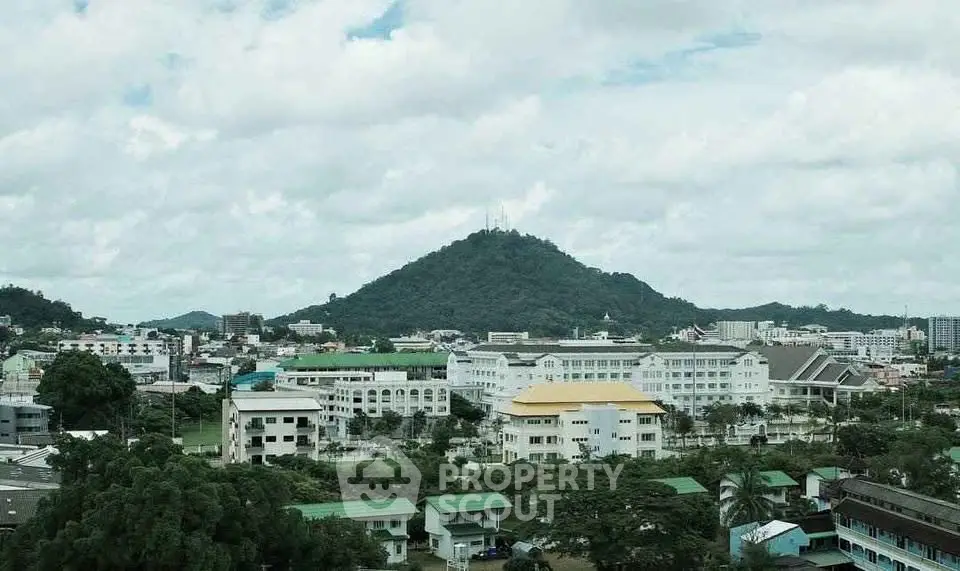 Scenic cityscape with lush greenery and mountain backdrop, ideal for real estate investment.