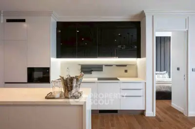 Modern kitchen with sleek design and open layout adjacent to a cozy bedroom.