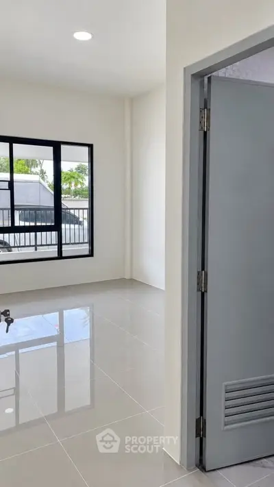 Bright and modern interior with large windows and glossy tiled floors, perfect for a stylish living space.