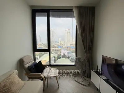 Modern living room with city view, featuring cozy seating and large windows.