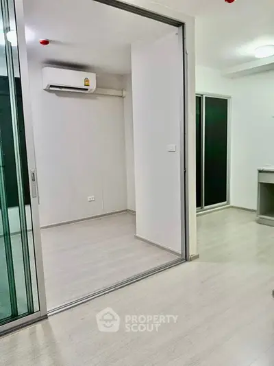 Modern apartment interior with sliding glass doors and air conditioning unit.