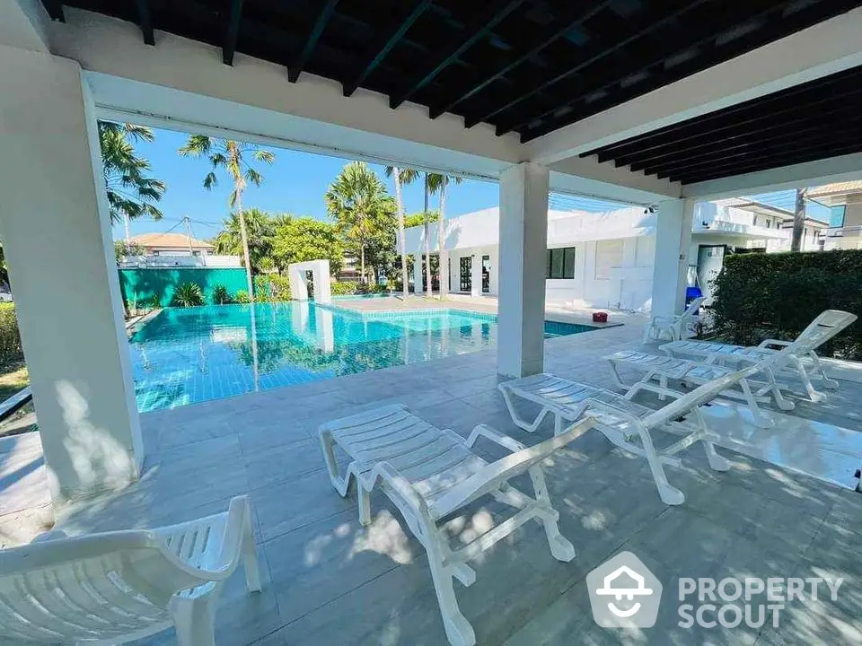 Luxurious poolside view with sun loungers and tropical landscaping