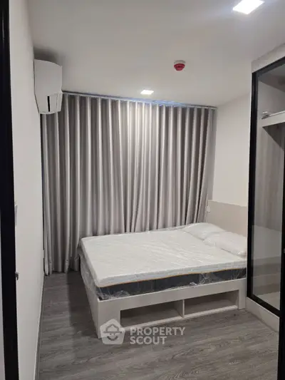 Modern bedroom with sleek design, featuring a bed with storage and elegant curtains, perfect for urban living.