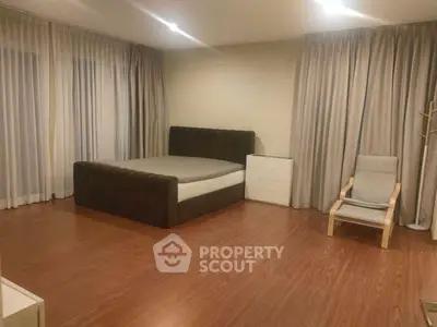 Spacious bedroom with modern decor and wooden flooring