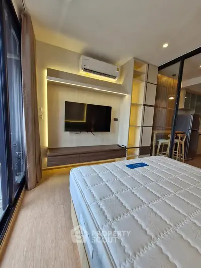 Modern bedroom with stylish built-in TV unit and air conditioning, featuring a cozy ambiance and sleek design.