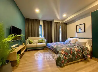 Spacious bedroom with modern decor, featuring a cozy bed, stylish sofa, and elegant wooden flooring.