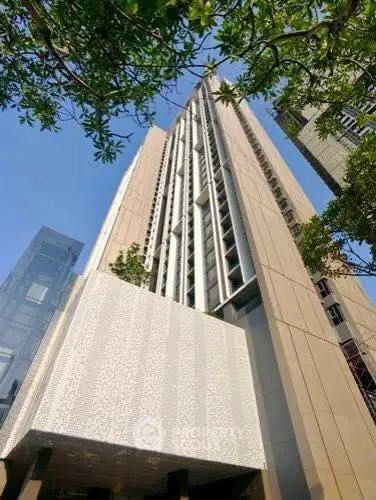 Stunning modern high-rise building with sleek architectural design and lush greenery.