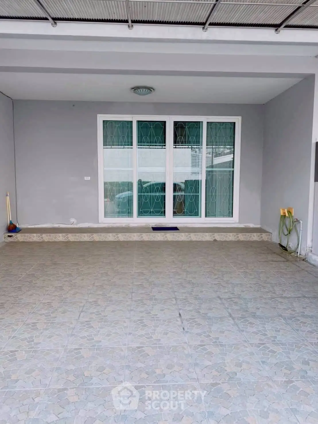 Spacious tiled entrance with large window and modern design, perfect for welcoming guests.