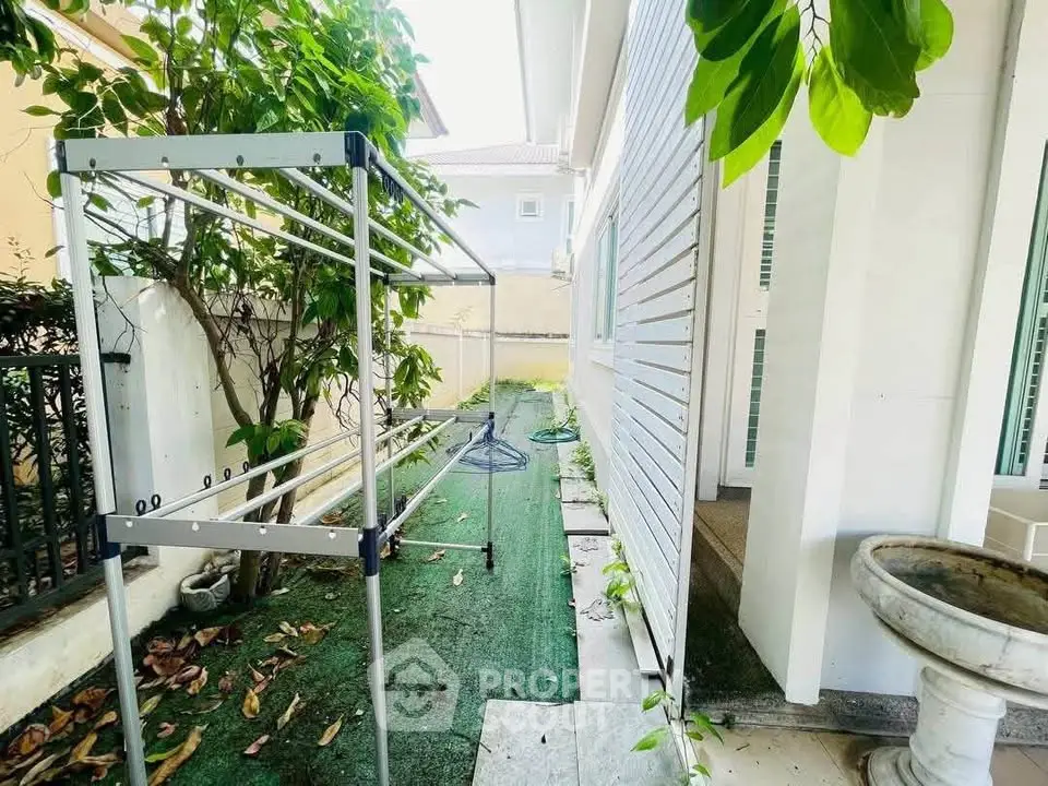 Charming side yard with greenery and laundry area in a suburban home