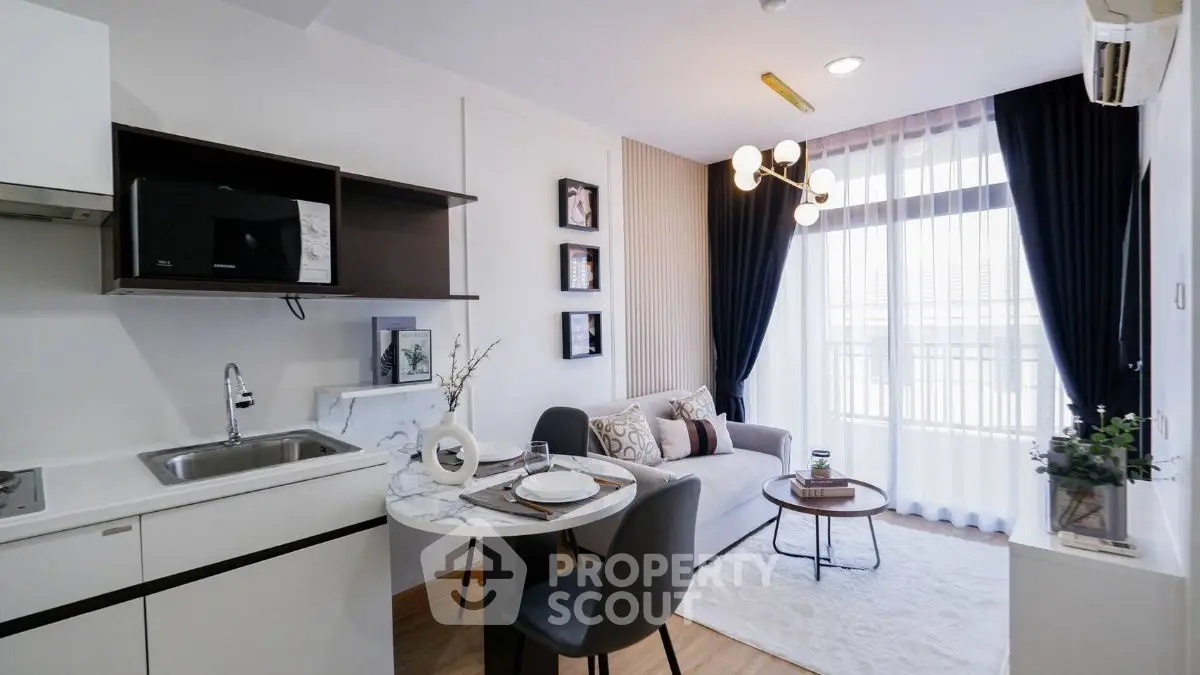 Modern living room with chic decor and open kitchen layout, featuring elegant lighting and cozy seating.