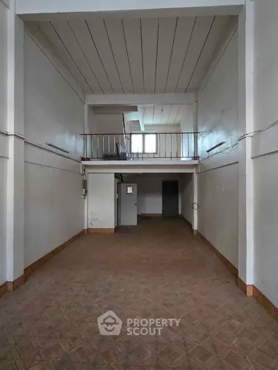 Spacious interior with high ceiling and mezzanine, ideal for creative use.