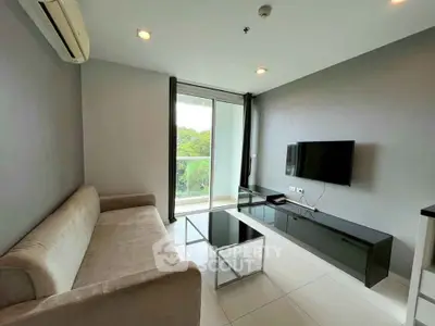 Modern living room with sleek furniture and balcony view, perfect for urban living.