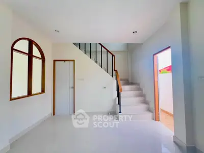 Bright modern interior with staircase and large window, perfect for stylish living.