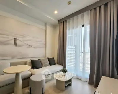 Modern living room with elegant decor and large window offering natural light.