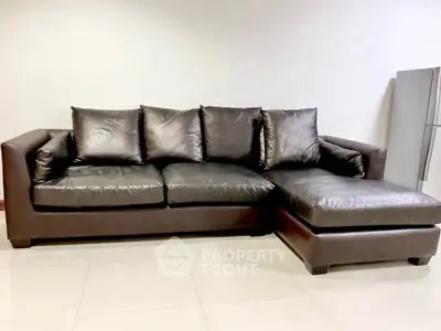 Luxurious leather sectional sofa in modern living room with sleek refrigerator