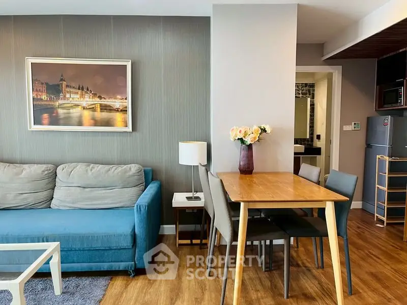 Modern living room with stylish decor and dining area, featuring a cozy sofa and elegant wooden flooring.