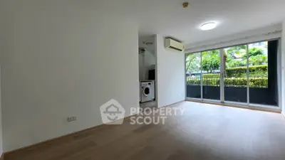 Spacious living room with large windows and garden view in modern apartment.