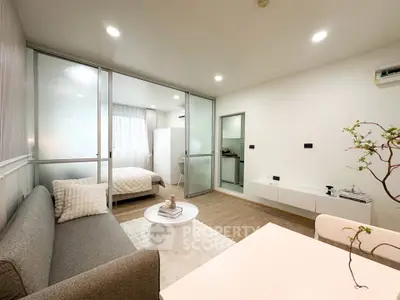Modern open-plan living room with cozy bedroom, stylish decor, and natural light.