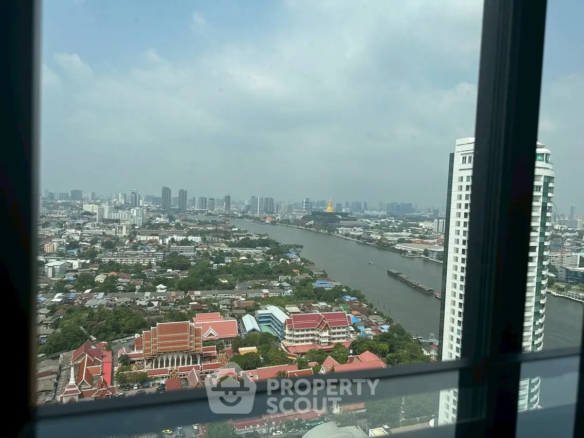 Stunning cityscape view from high-rise window overlooking river and skyline.