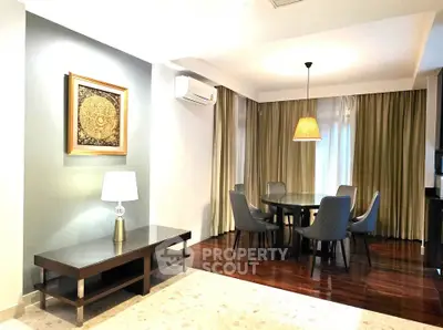 Elegant dining area with round table and stylish chairs, featuring warm lighting and modern decor.