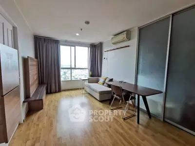 Modern living room with wooden flooring and city view, featuring a cozy sofa and sleek dining table.