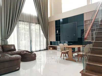 Luxurious modern living room with high ceilings, elegant curtains, and stylish furniture