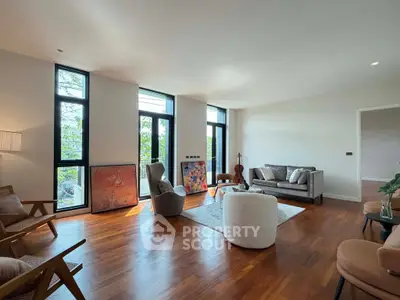 Spacious modern living room with large windows and elegant wooden flooring.