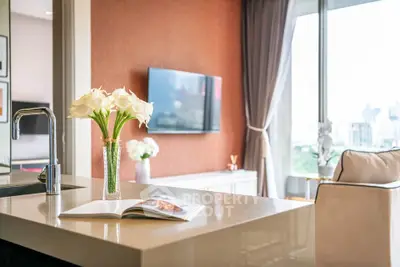 Modern living room with elegant decor and city view, featuring a sleek kitchen island.