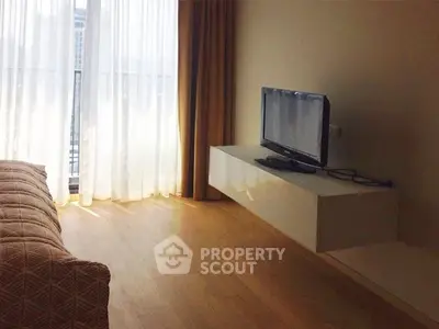 Modern living room with sleek TV setup and floor-to-ceiling windows.