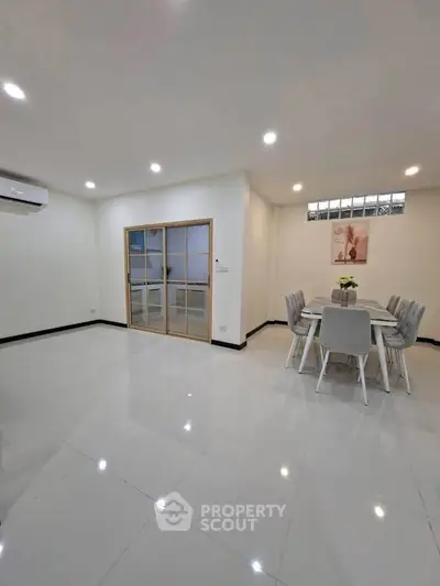 Spacious modern dining area with sleek tile flooring and elegant lighting
