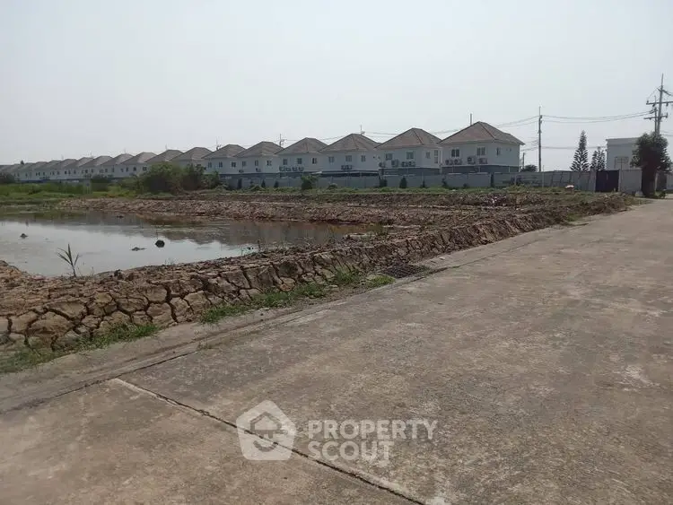 Spacious residential development with row of modern houses and open land.