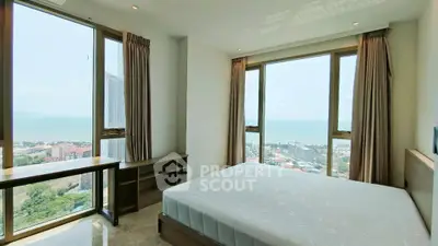 Stunning bedroom with panoramic ocean view and large windows in a high-rise apartment.