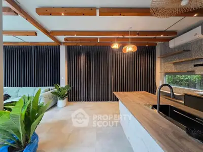 Modern living room with stylish wooden beams and open kitchen layout