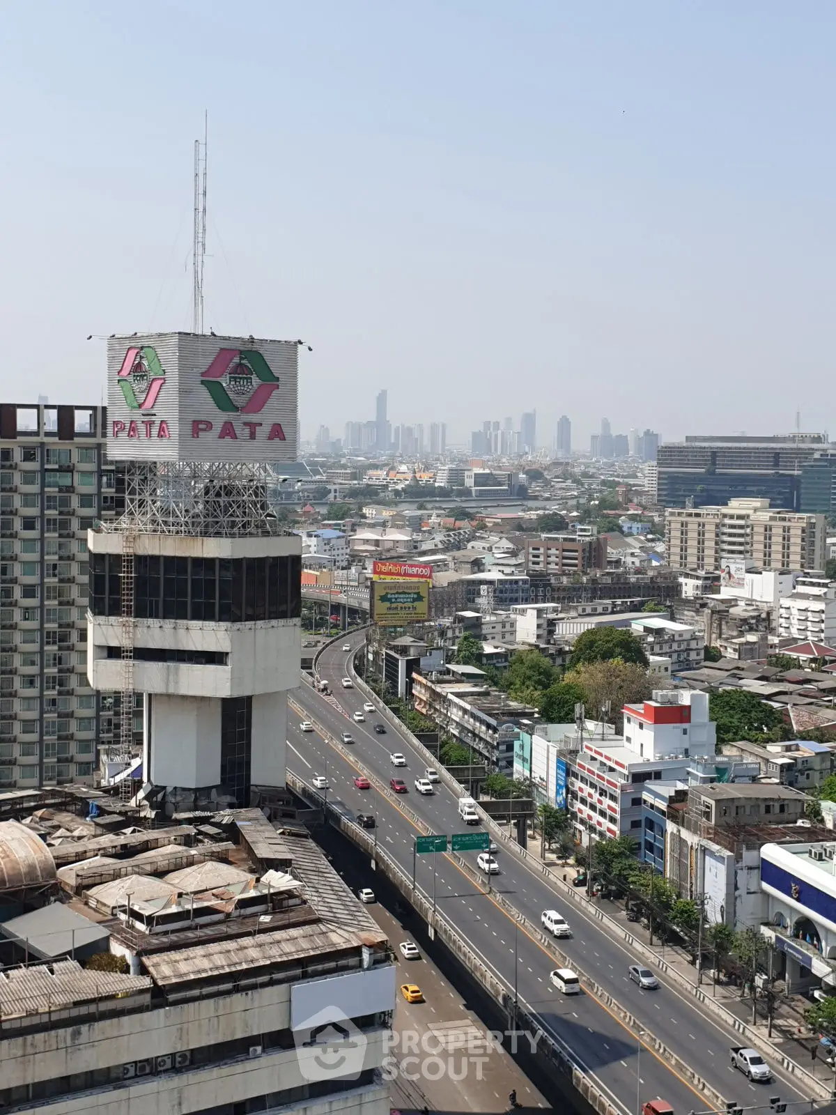 Stunning cityscape view with iconic building and bustling highway, perfect for urban living enthusiasts.