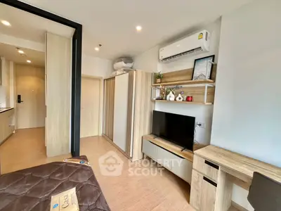 Modern bedroom with air conditioning, TV, and stylish wooden furniture in a cozy apartment.