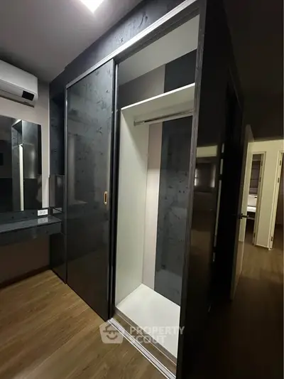 Modern bedroom with sleek sliding wardrobe and wooden flooring