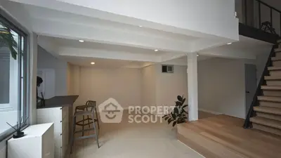 Modern open-plan living area with stylish staircase and natural light