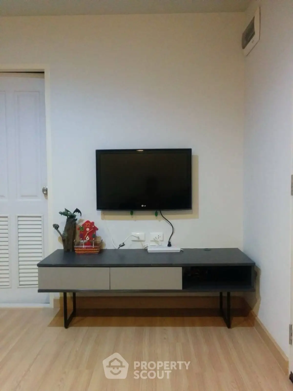 Modern living room with wall-mounted TV and sleek console table.