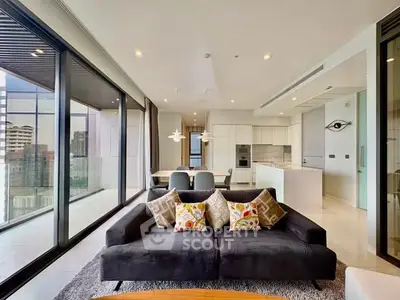Luxurious modern living room with floor-to-ceiling windows and open kitchen layout in high-rise apartment.