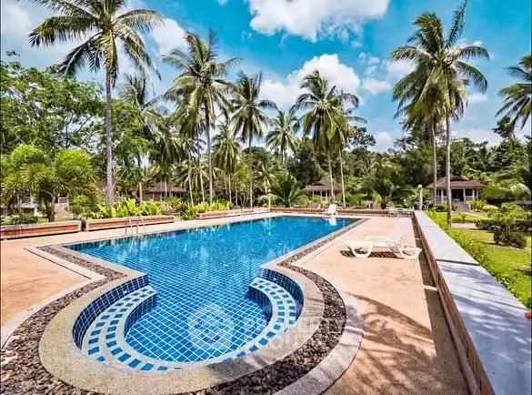 Stunning tropical pool area with lush palm trees and serene surroundings.