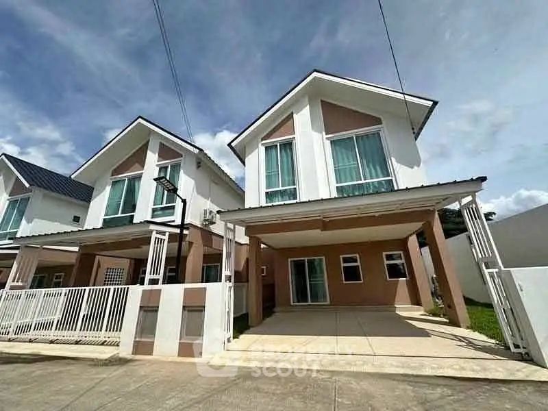 Modern two-story house with driveway and gated entrance in a suburban neighborhood.