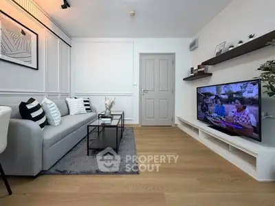 Modern living room with sleek decor, cozy sofa, and wall-mounted TV in a stylish apartment.