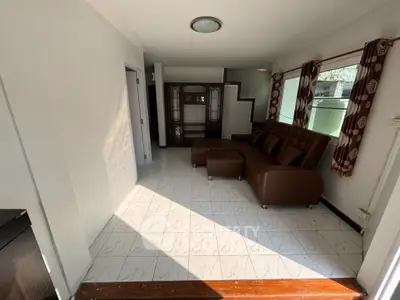 Cozy living room with brown sofa and natural light, perfect for relaxation.