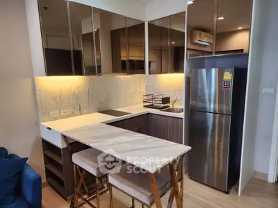 Modern kitchen with sleek cabinetry, marble countertops, and stainless steel appliances in a stylish apartment.