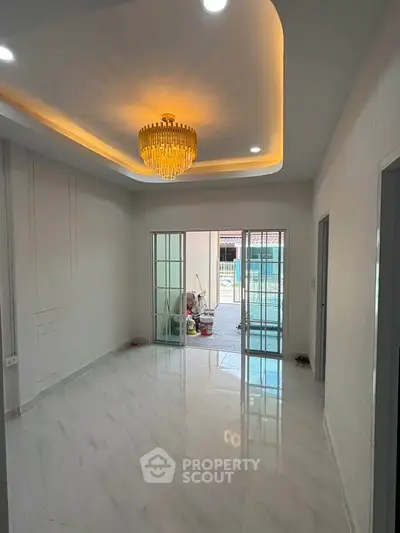 Spacious living room with elegant chandelier and sliding glass doors