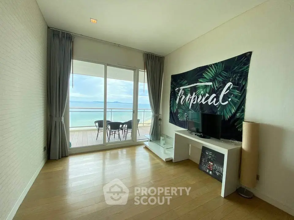 Spacious living room with ocean view and balcony access in modern apartment.