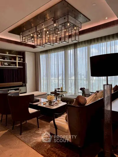 Luxurious living room with elegant chandelier and floor-to-ceiling windows offering a stunning view.