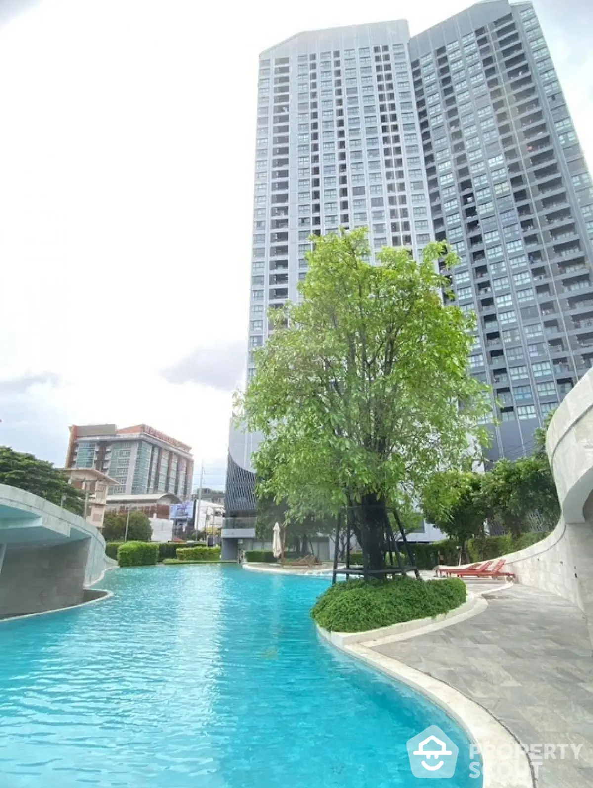 Luxurious high-rise building with stunning pool and lush greenery